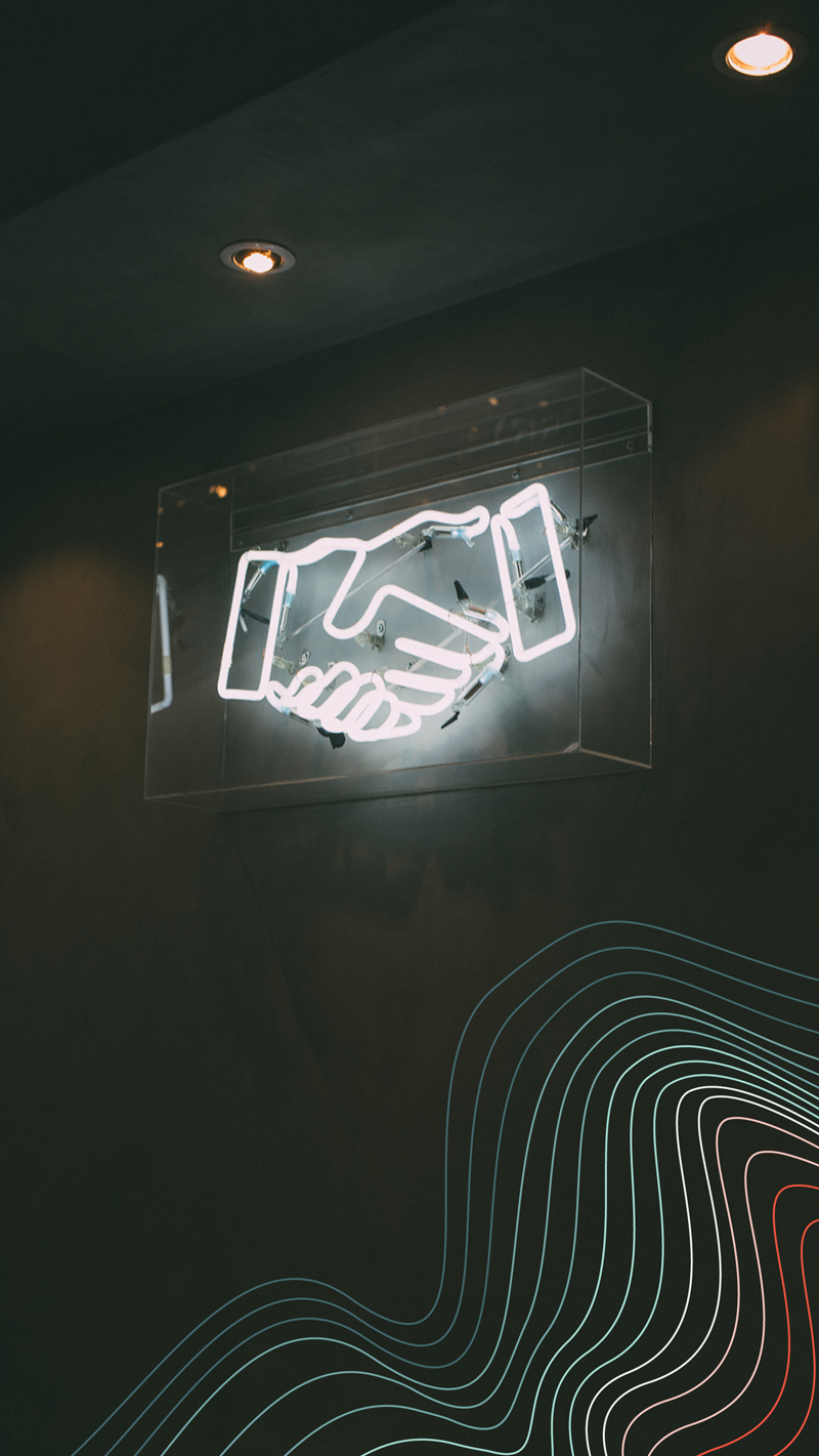 Neon sign of two hands shaking